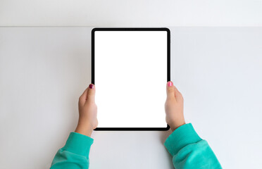 Girl's hands with tablet in a top view flat lay, featuring an isolated screen for mockup. Create a modern aesthetic for digital content and app presentations