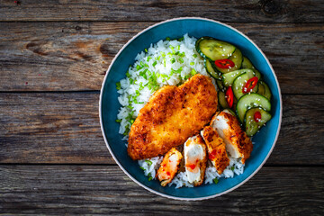 Tonkatsu - crispy Japanese pork chop with white rice and  fresh vegetables on wooden table
