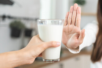 Allergy asian young woman, girl hand in deny, no or push out to avoid for drink milk at home,...