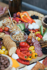 Appetizer board with nuts, crackers, fresh fruit and vegetables.