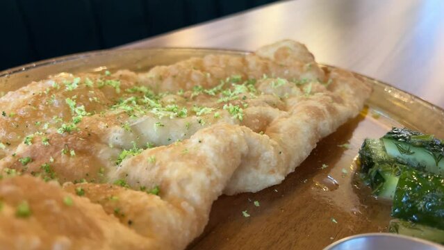 fast food cheburek and cheeseburger dinner for three french fries tea cups set on the table in a restaurant various sauces beautiful green dishes. expensive for rich
