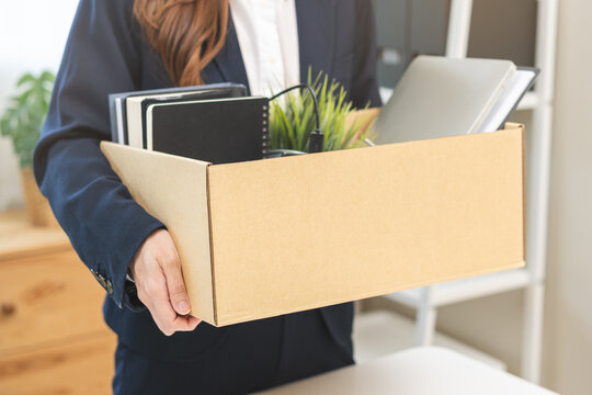 Unemployment, quitting job concept, desperate asian young business woman resigning or fired, leave from company, female holding belongings, stuff into box cardboard, layoff or leaving, changing work.