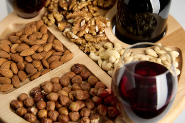 A nutty appetizer for wine for a romantic dinner. On a round wooden plate with dividers, delicious...