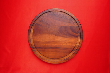Wooden plate or container for holding pizza on the elegant red background kitchen equipment