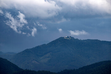 Dramatic clouds over small hiltop church in Slovenia.