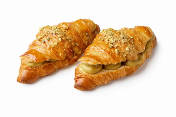 Two pistachio cream croissants on white background