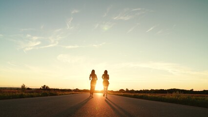 two friends running sunset, team group girls running sunset, silhouette athletic girls, teamwork...