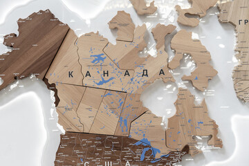 Wooden map of Canada and neighboring countries, names of countries in Russian. Map for trip planning.
