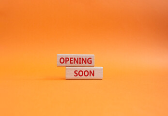 Opening soon symbol. Concept word Opening soon on wooden blocks. Beautiful orange background....