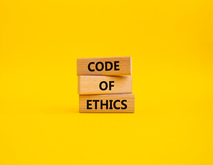 Code of ethics symbol. Concept words Code of ethics on wooden blocks. Beautiful yellow background. Business and Code of ethics concept. Copy space.
