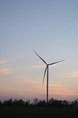 Obraz premium Wind Turbine at Sunset: Renewable Energy, Sustainable Power, and Nature