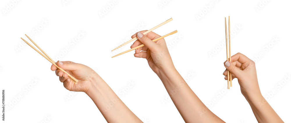 Wall mural a set of female hands holding wooden chopsticks for sushi or rolls on a blank background.