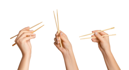 A set of female hands holding wooden chopsticks for sushi or rolls on a blank background.