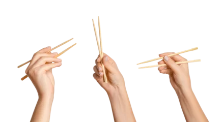 Foto op Canvas A set of female hands holding wooden chopsticks for sushi or rolls on a blank background. © MM