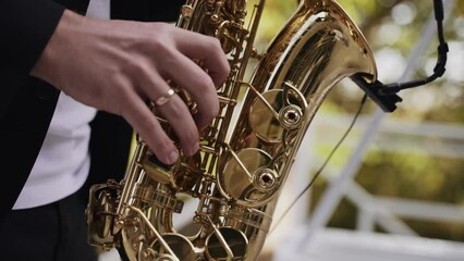 A saxophonist in a suit playing a golden saxophone outdoors with a blurred greenery background, a classic image of live jazz music.