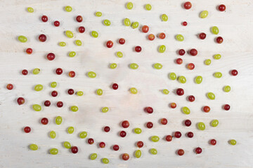Top view of red and green grapes sprinkled on white weathered board