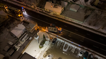 Drone photography of emergency service fixing broken electrical pole in a city during winter snowy...