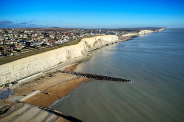 Aerial view of the white chalk cliffs and undercliff walk at Rottingdean village in East Sussex, with Saltdean and Peacehaven in the background.