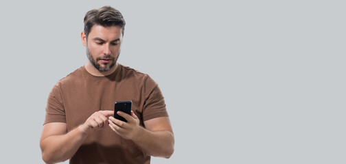 Man using mobile phone isolated over studio background. Man using smart phone cellphone for calls,...