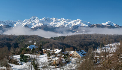 Fototapeta na wymiar View of the snow-capped Pyrenees and village in winter in south-west France