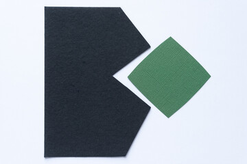 black paper shape with arrows or triangle or zig zag edges and rounded green paper tile on blank...