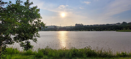 boy playing in a lake in a park in the late afternoon with the sunset in the background