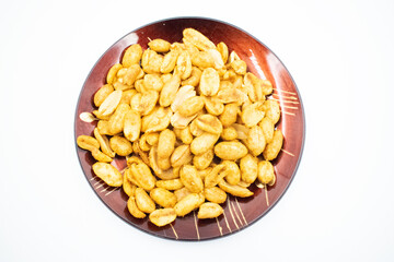 cooked peanuts in the wooden plate, isolated on white background, top view
