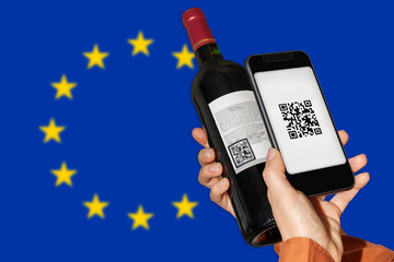 E-labeling of wine product in EU. Person scans QR code on label of wine bottle using mobile phone...