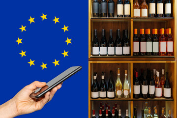 Mobile phone in front of wine bottles and flag of European Union. 