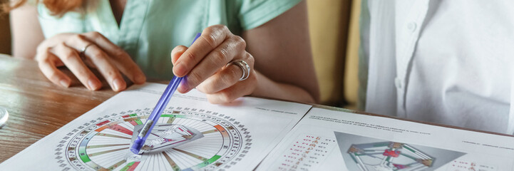 Tver, Russia - August 2, 2021. A woman in a cafe at a table is studying the design of a person. The...