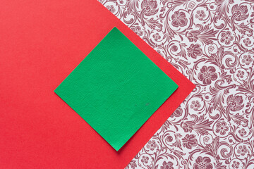 green square on red paper and decorative scrapbooking paper with floral and swirls pattern