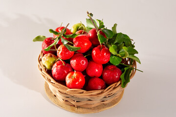 Freshly Harvested Organic Acerolas in a Basket on a white table and clean background