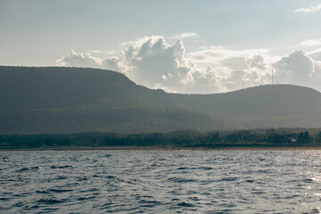 point de vue sur l'eau avec vue sur une montagne en arrière plan et des nuages dans le ciel en été