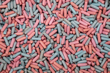Heap of delicious pink and blue chewy candies, colorful bright background, top view.