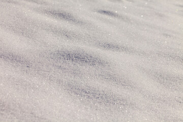 From above of smooth surface of white snow texture  on sunny winter day as background