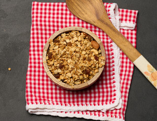 Oatmeal, raisins, cashews and almonds. Granola in a wooden plate