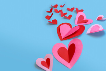 Beautiful paper hearts arranged on a sky-blue background. Greeting card concept for Valentine's Day. Mother's Day. copyspace