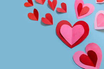 Beautiful paper hearts arranged on a sky-blue background. Greeting card concept for Valentine's Day. Mother's Day. copyspace