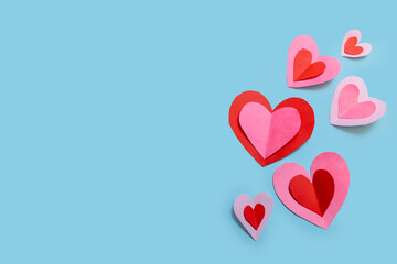 Banner with cute and delicate paper hearts arranged on a sky-blue background. Concept for Valentine's Day, Mother's Day, love, and friendship.