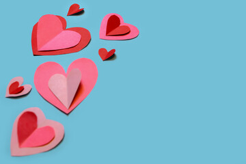 Banner with cute and delicate paper hearts arranged on a sky-blue background. Concept for Valentine's Day, Mother's Day, love, and friendship.