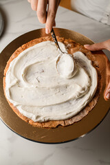 Spreading white delicious cream on cakes on a cake stand