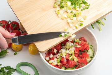 Add chopped green onions to chopped vegetables to make a salad.
