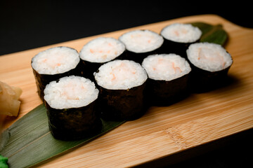 Portion of sushi rolls served on banana leaves side view