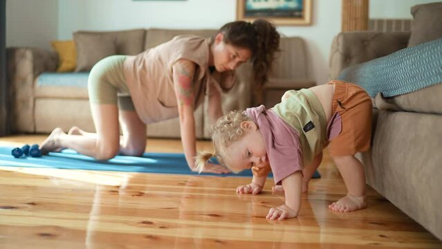 mother and toddler kid doing stretching exercises training together cozy home. Funny asian family young healthy mom teaching cute little kid daughter meditate together sit floor, japanese mother child