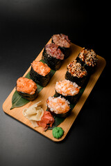 Set of sushi rolls with pieces of different types of fish and red caviar