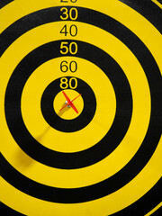 Dartboard with dart arrow in bullseye, close up