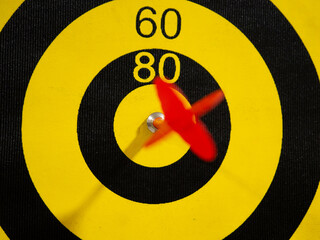 Dartboard with dart arrow in bullseye, close up