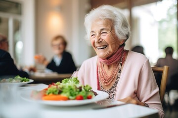An elderly woman is enjoying her salad in a restaurant - obrazy, fototapety, plakaty
