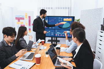 Businessman presenting data analysis dashboard display on TV screen in modern meeting for marketing...