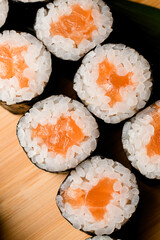 Portion of sushi with pieces of trout on a wooden board